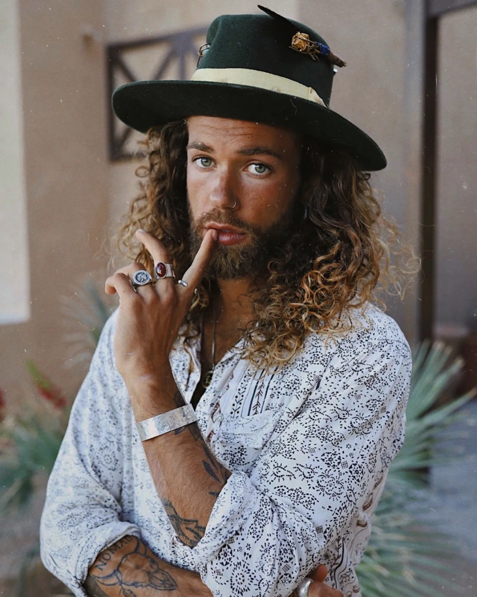 Curly-haired man in a black wide-brim hat