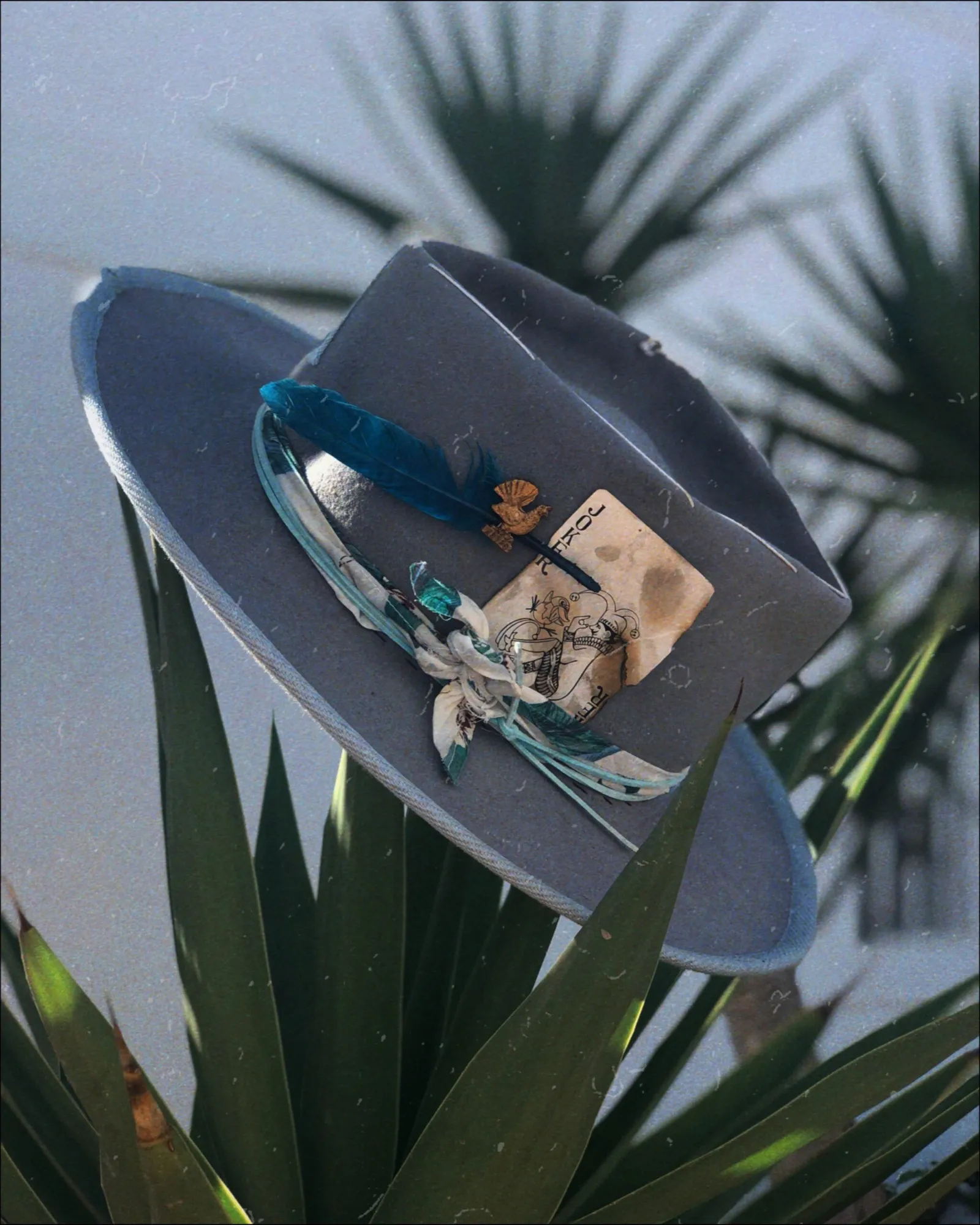 Decorated blue hat resting among palm leaves