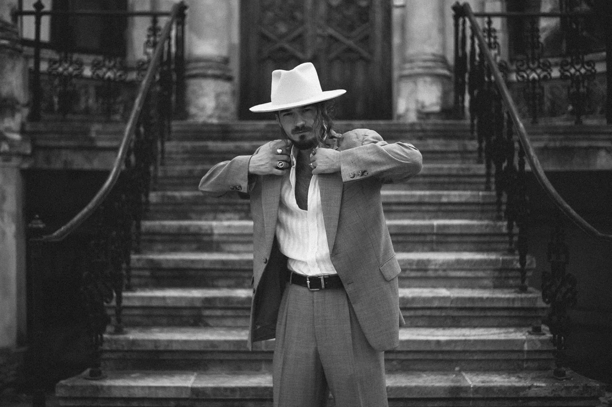 Man in a white hat on stone stairs, black and white